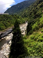 Río pedregoso, hermoso valle y verdes colinas, la ruta de las cascadas en Banos. Ecuador, Sudamerica.