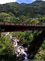 A ponte, rio e colinas, gosta do cenário na capital de aventura, Banos. Equador, América do Sul.