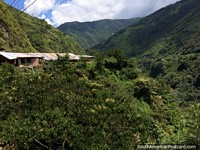 Casas nas colinas, perto e distante, uma colocação assombrosa para viver em e em volta de Banos. Equador, América do Sul.