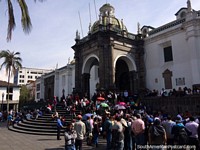 As pessoas de Quito reúnem-se para escutar um falante público em Praça da Independência do lado de fora da catedral.