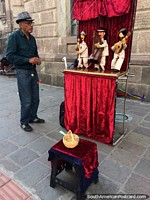 O homem entretém o transeunte com uma demonstração de marionete musical no centro histórico de Quito.
