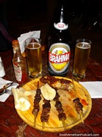 Steak kebabs on sticks with chicha and beer in Ybycui. Paraguay, South America.