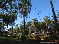 Flags fly at Plaza de Armas main square in Encarnacion. Paraguay, South America.