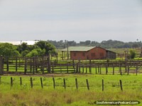 Versión más grande de Cercas de madera y puertas por una granja en Gran Chaco.
