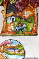 La placa de cerámica de pared de una casa de campo, la mujer y el burro, hecho en Areguá. Paraguay, Sudamerica.