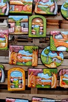 A colorful array of wall plaques depicting beautiful country life scenes, ceramics from Aregua.