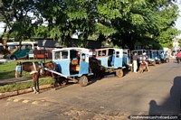 Horse drawn cart taxis await people outside the Villarrica bus terminal. Paraguay, South America.