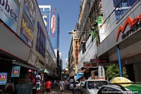 As ruas alinham-se com alamedas muito altas e lojas em todo lugar em Cidade do Este. Paraguai, América do Sul.