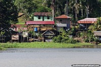 Group of houses on a property riverside in the Amazon.