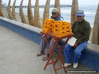 Larger version of Men selling honey made food product in Huanchaco, bees are buzzing around it.