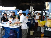 Verso maior do Uma cozinha existente ao ar livre em Moquegua, o homem faz rolos de abacate.