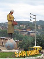 Woman with basket standing on globe, monument in San Ignacio. Peru, South America.