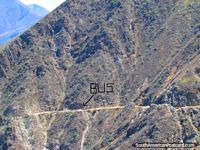 O ônibus no caminho de rochedo ïngreme ananica-se pelas enormes caras de montanha entre Leymebamba e Celendin. Peru, América do Sul.