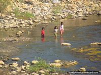 3 girl children cross a river north of Cajabamba. Peru, South America.