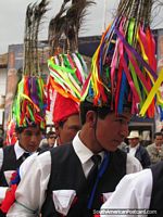 Young men wear hats of colored strips and feathers at Feria Patronal, Huamachuco. Peru, South America.