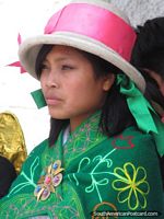 Beautiful young woman in Huaraz with white hat, pink ribbon and green shawl with flowers. Peru, South America.