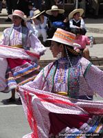 2 women in traditional dresses dance in a Huaraz street. Peru, South America.