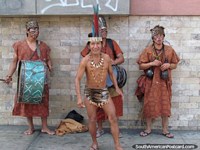 Larger version of An indigenous musical group in costumes perform on the street in Lima.