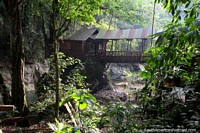 Cabana e ponte acima do rio e floresta em Balneario Cueva das Pavas (caverna) em Tingo Maria. Peru, América do Sul.
