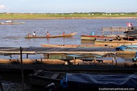 Versão maior do Os barcos de rio encabeçam de cima para baixo do rio, os habitantes locais, o Rio Ucayali em Pucallpa.