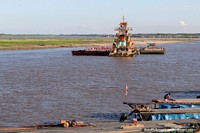 Tugboat in control of some barges on the Ucayali River in Pucallpa. Peru, South America.
