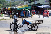 Man and trolley cart, street stalls and mototaxis, Tingo Maria. Peru, South America.