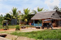 Larger version of Thatched roof houses, palm trees and mototaxis, Amazon living, south of Yurimaguas.