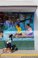 Larger version of Man and woman paddling their canoe, mural in Yurimaguas, children run past.