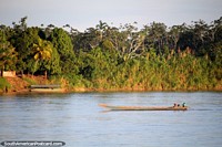 Motorized river canoe powers up the Huallaga River near Yurimaguas. Peru, South America.