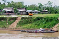 Grupos de casas e pessoas em canoas no Distrito de Santa Cruz, ao sul de Lagoas. Peru, América do Sul.