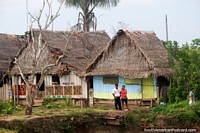 Casas de telhado cobertas com palha ao longo dos bancos do Rio Maranon em Maipuco, o Amazônia. Peru, América do Sul.