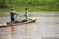 A man and son set fishing nets in the Amazon River in Alfaro, west of Santa Rosa. Peru, South America.