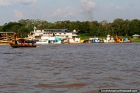 View of Leticia Colombia across the Amazon River as we leave Santa Rosa Peru by riverboat. Peru, South America.