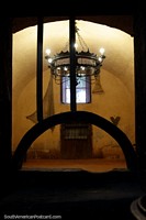 Versión más grande de Una antigua sala de piedra vacía con una antigua lámpara de araña en la mansión del fundador en Arequipa.