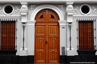 Larger version of Beautiful building facade in Arequipa with arched wooden door and window shutters.