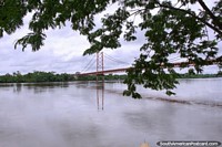 Versão maior do Lance uma ponte sobre as águas de rio e calmas em Porto Maldonado.
