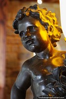 Criança em luz dourada, escultura de bronze dentro do castelo em Lamas. Peru, América do Sul.