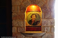 Woman holds a book and pen under an orange light, sanctuary at the Lamas castle.