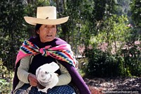Woman with white hat and colored shawl in the countryside around Chota.