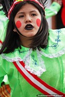 Young lady with large red dots painted on her face, street show in Chota.