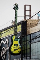 Giant electric guitar on a building side in Chimbote, live music venue.