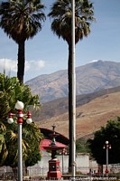 Plaza en Caraz con fuente y altas palmeras, montañas lejanas. Perú, Sudamerica.