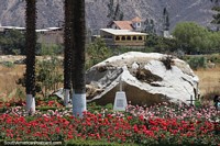Memorial to the Vergara family at Campo Santo in Yungay, flowers and boulder. Peru, South America.