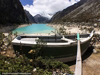 Row a boat out onto Paron Lake with turquoise waters in the mountains in Caraz. Peru, South America.