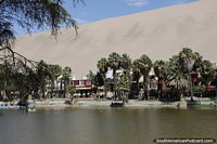 Hoteles, restaurantes, palmeras y arena alrededor de la laguna de Huacachina. Perú, Sudamerica.