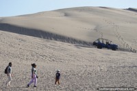 People walk to buggy station to ride around the sand dunes in Huacachina. Peru, South America.