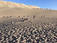 Mais areia do que praia, as pessoas esperam o pôr do sol em Huacachina. Peru, América do Sul.