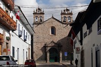 Versão maior do Igreja de pedra com torres de sino em uma rua lateral em Cusco.