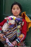 Girl with her lamb poses for a photo in Cusco.