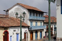 Edifício antigo com varandas de madeira e persianas em Cusco.